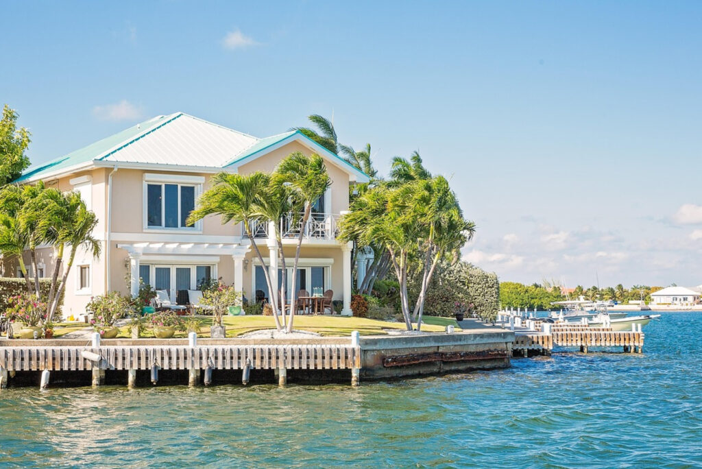 Coastal home with palms and a private dock beside the water